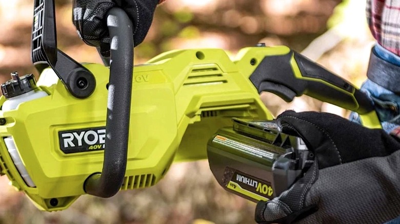 Person loading a 40V battery into a Ryobi tool.