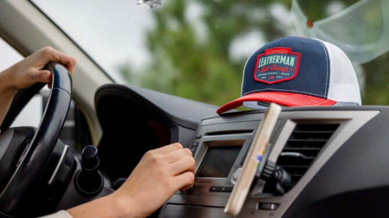 A Leatherman hat resting on a car dashboard.