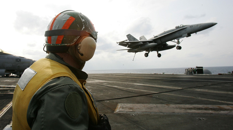 A fighter jet landing on an aircraft carrier