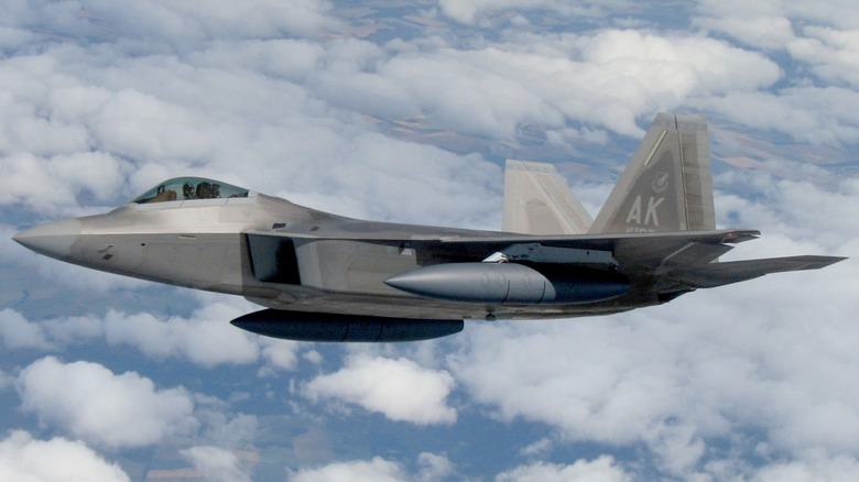 An F-22 Raptor flying high above the clouds in Alaska