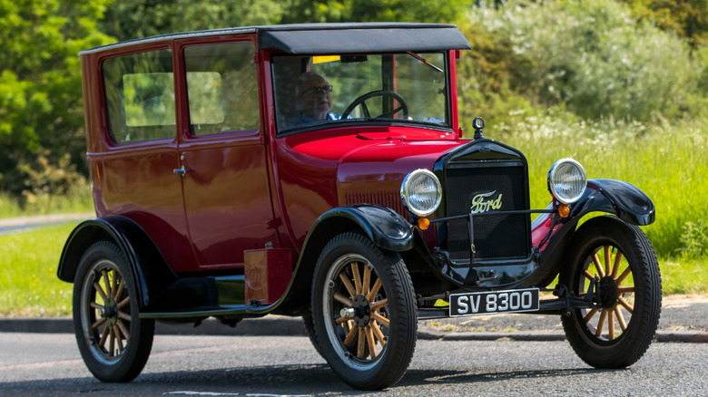 Red Ford Model T being driven on the road