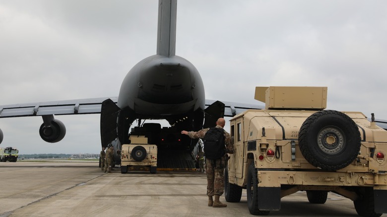 Airmen loading HMMWVs onto a C-5M Super Galaxy