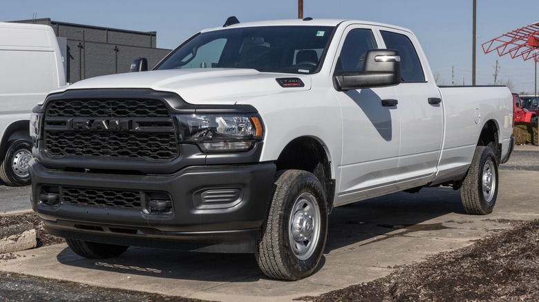 A basic RAM 2500 Tradesman in white outside a dealership, front 3/4 view
