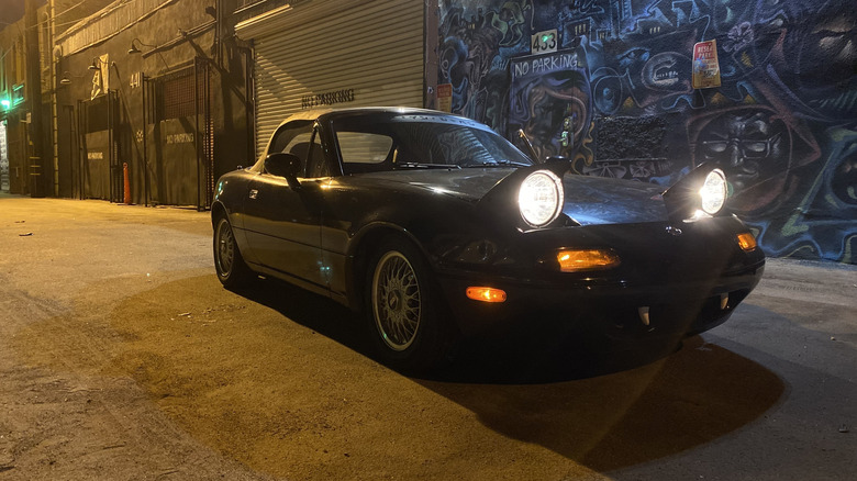 1993 Mazda Miata with headlights on at night