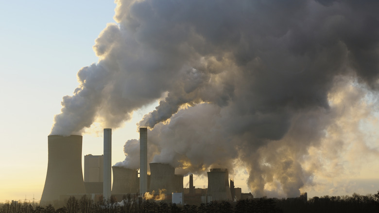 Coal-fired power station, belching fumes into a blue sky.