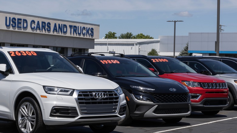 Used car dealership lot with prices in windshields