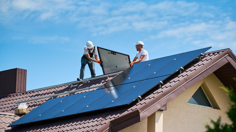 Workers installing solar panels on a home's roof