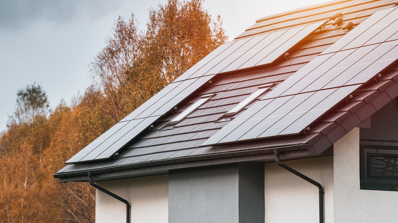 A Photo of a Modern Home with Solar Panels and Autumn Trees.