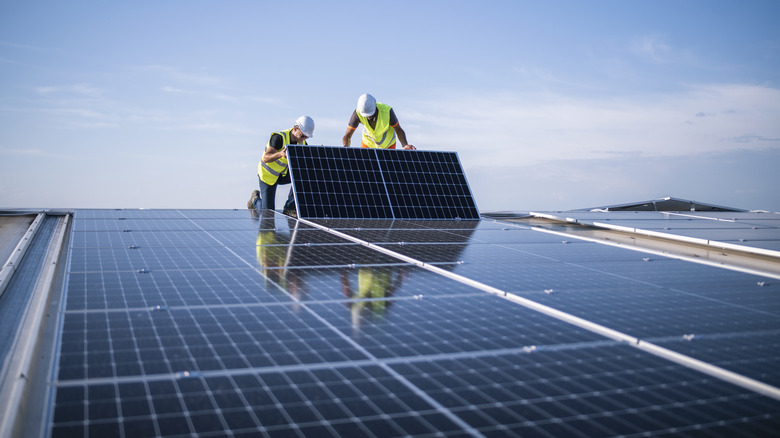 Engineers installing solar panels on a roof