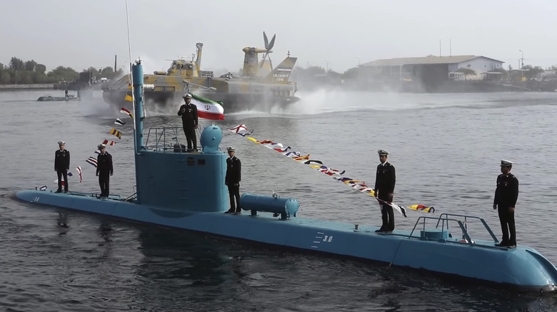 Iran navy crewmembers stand aboard submarine in port.