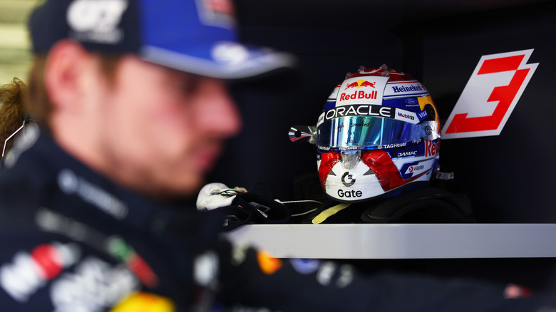 Red Bull Formula 1 racing helmet with Max Verstappen out-of-focus in foreground