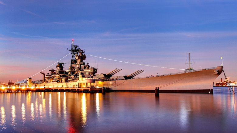 The battleship USS New Jersey lit up at dusk