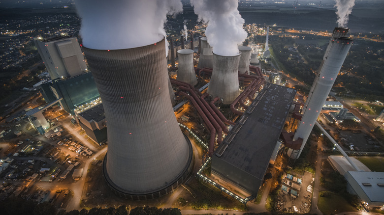 Aerial three quarter view of a coal plant belching smoke into the air