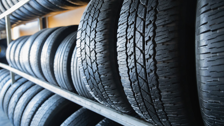 Modern tires arranged on a rack in a tire workshop.