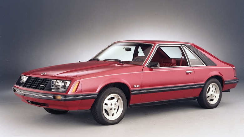 Red 1979 Ford Mustang fastback against a white studio background