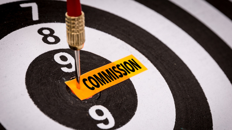 Arrow hitting 'commission' on a dart board