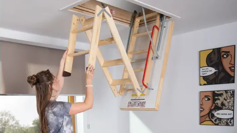 A woman pulling down a Fakro LTK Energy Attic Ladder