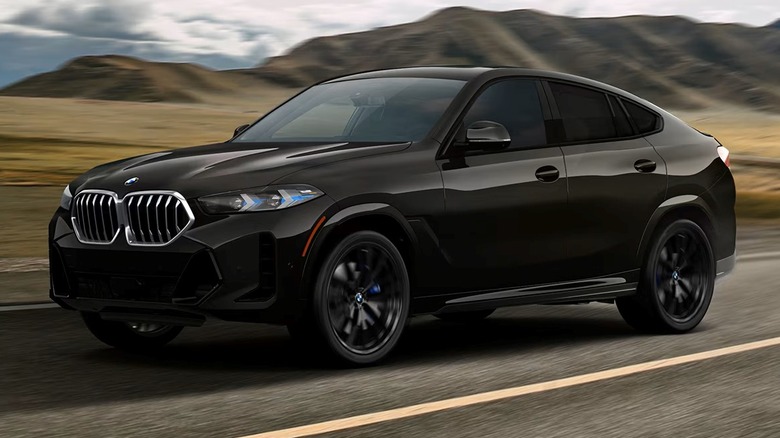 BMW X6 xDrive40i driving on a road with hills in the background