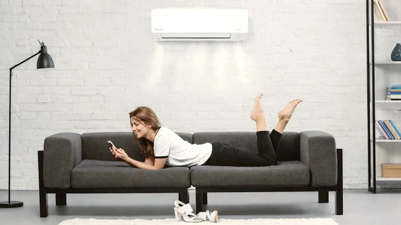 Woman laying on a couch underneaths a Daikin mini split system