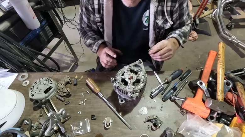 A person using a rebuild kit to repair an alternator