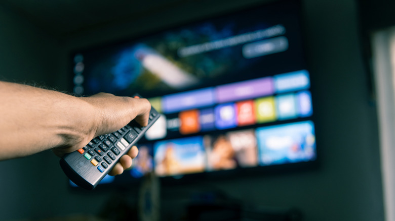 Person using a TV remote to browse content on a smart TV