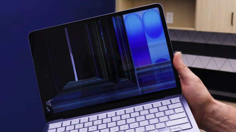 A purple MacBook Neo with a damaged display