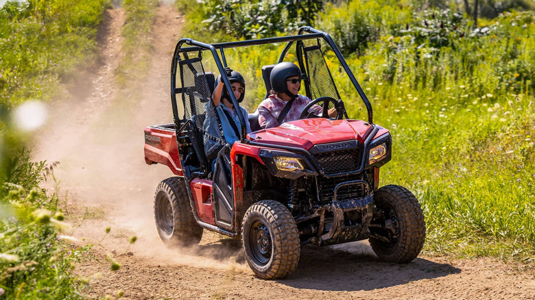 Front angle view of a driver and passenger in a Honda Pioneer 520