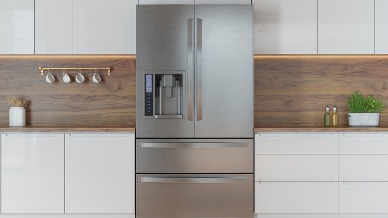 A refrigerator in the middle of a kitchen.