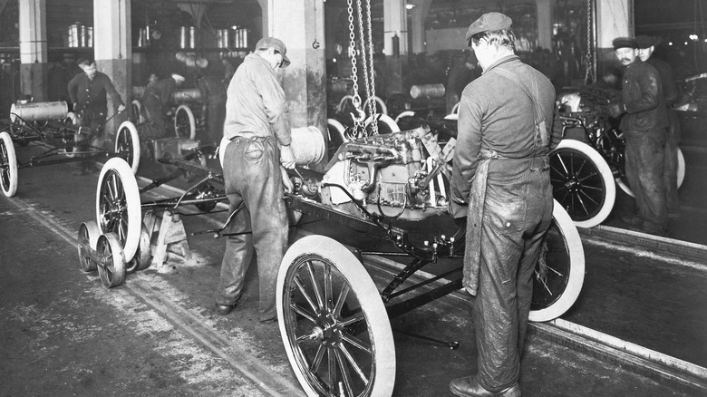 Factory workers assembling a Ford Model T