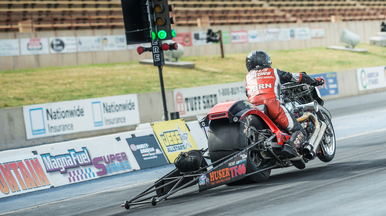 A Top Fuel Harley pilot pops a wheelie at the green light