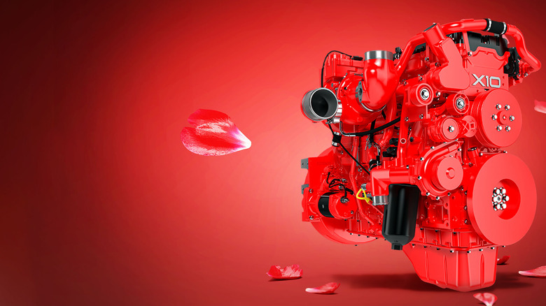 Cummins X10 engine with red background and floating rose petals.