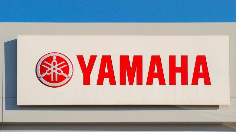 A sign on a building with the Yamaha brand logo in white and red.