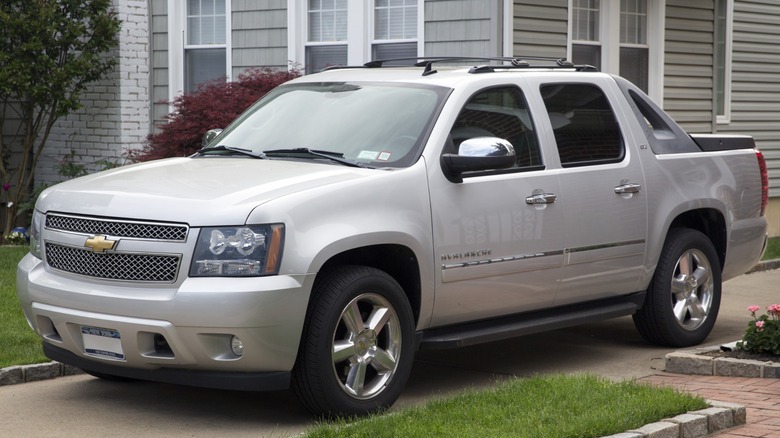 A silver 2011 Chevrolet Avalanche LTZ parked in a driveway