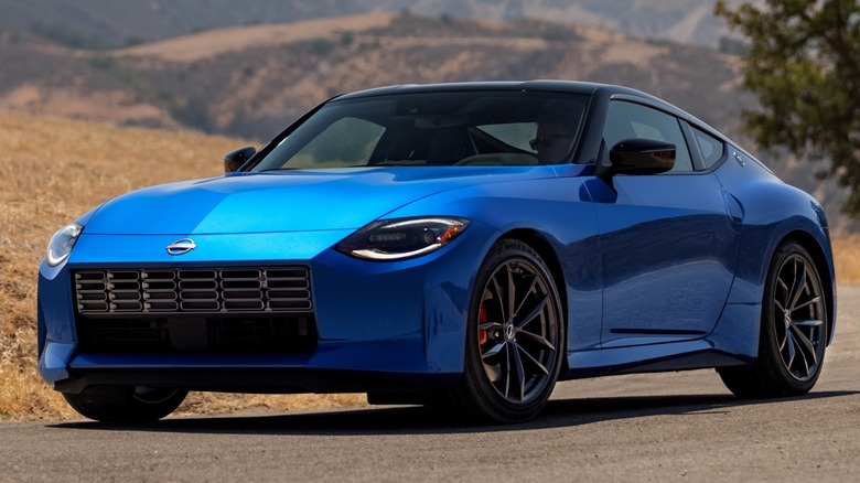 Nissan Z parked on an asphalt road with mountains in the background