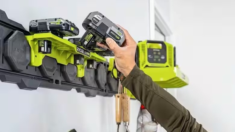 Hand putting Ryobi battery on shelf