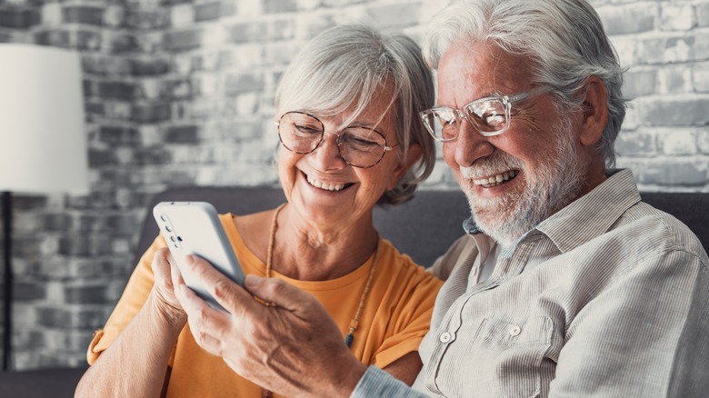gray haired couple smiling smartphone