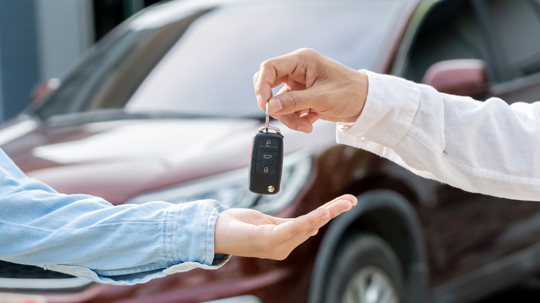 Dealer handing over car keys to a buyer