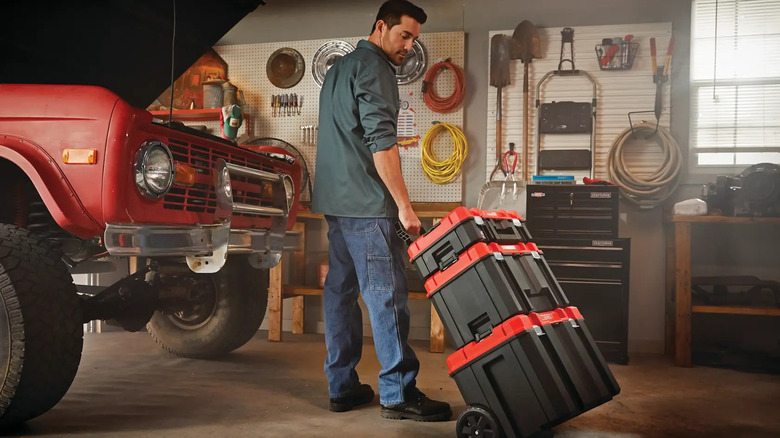 A man pulls a stack of Craftsman Versastack containers.