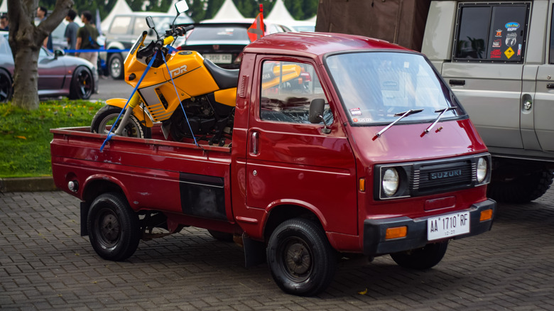 Suzuki Carry with motorcycle loaded in bed, front-right three-quarter view