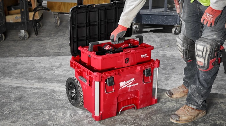 A person reaching for a Milwaukee Packout container