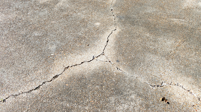 Cracks in concrete in three different directions, sunny day