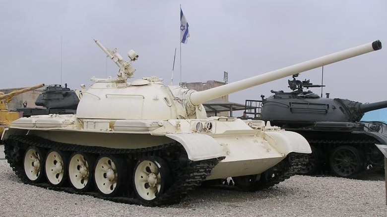 A white T-54 tank parked alongside other tanks