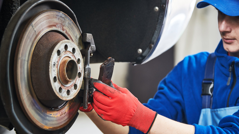 Hands holding two brake pads