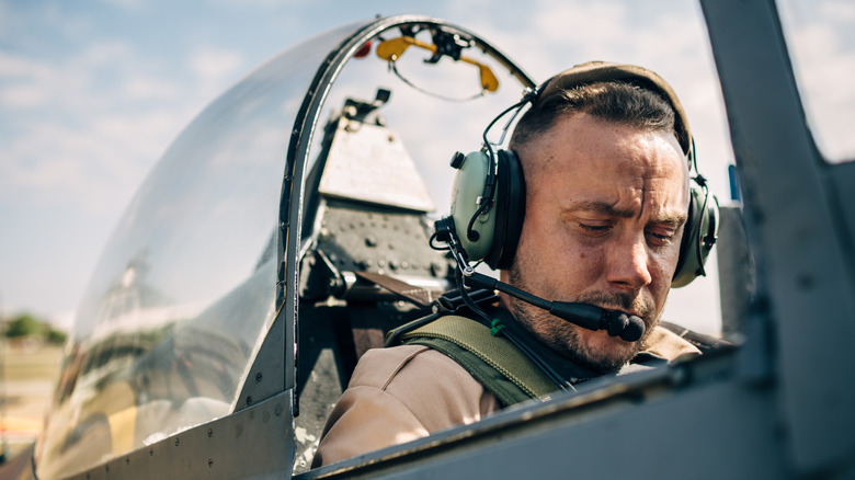 Pilot wearing a headset conducts a pre-flight check.