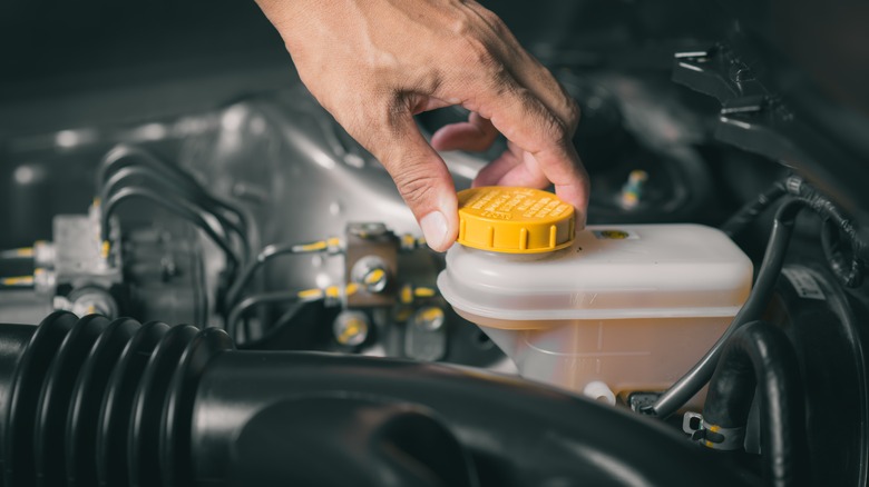 Mechanic inspecting the brake fluid reservoir