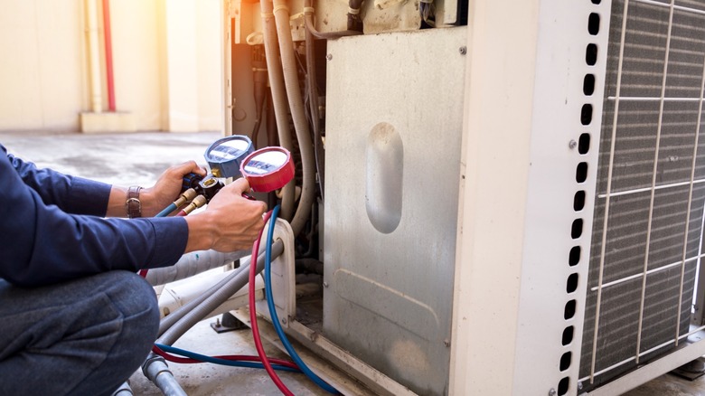 A professional servicing a home air conditioner.