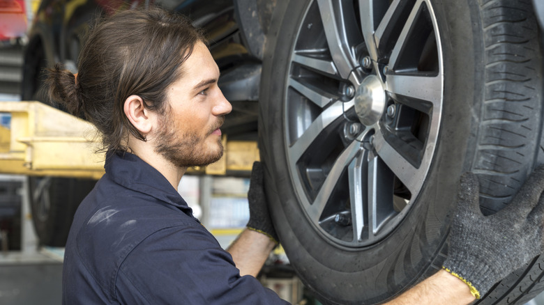 A mechanic replacing a wheel