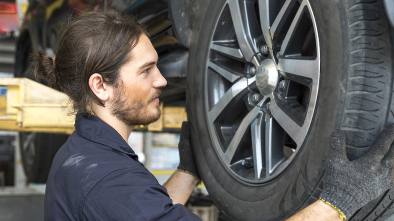 A mechanic replacing a wheel
