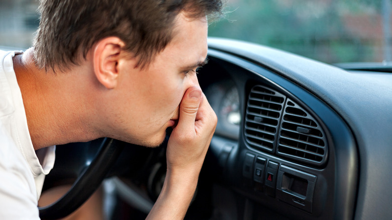 Man covers nose at A/C smell
