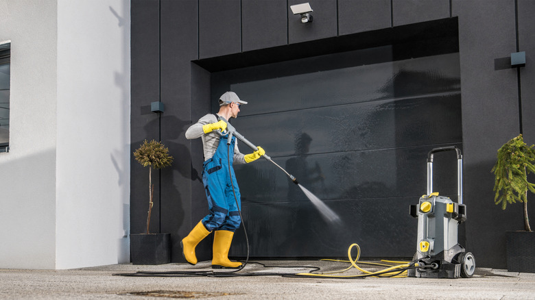 Man pressure washing his garage